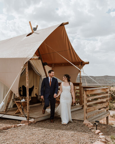 bride and groom standing outside tent
