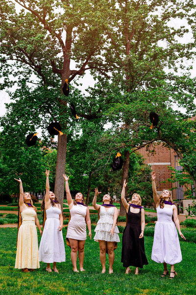 Law School graduated at Vanderbilt University tossing their caps and wearing cute dresses