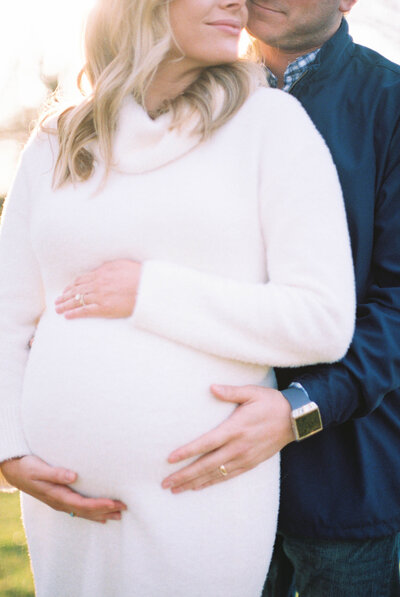 maternity portrait of couple holding stomach