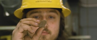 construction man holding at small rock
