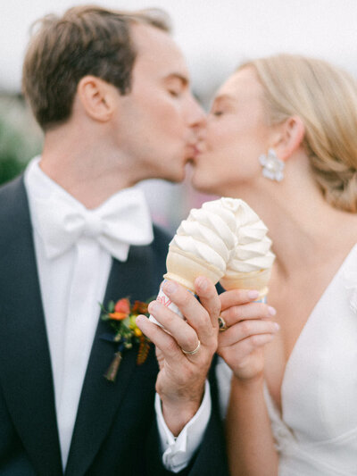 Couple kiss with creemees at their Stowe Vermont Wedding