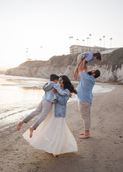 Family Photoshoot in Pismo Beach on the Central Coast with family candid dancing having fun playing