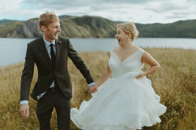 bride and groom run and laugh during their Gros Morne elopement