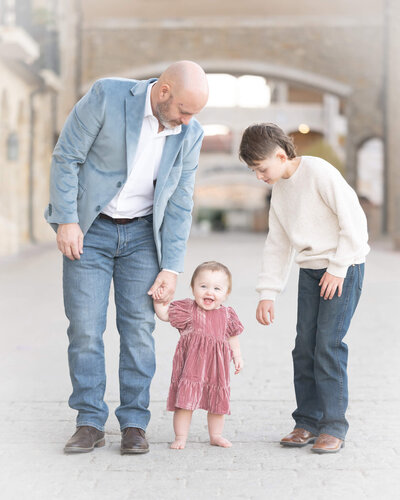 Father, and son holding hands of 1 year old baby in Adriatica  Village McKinney, texas