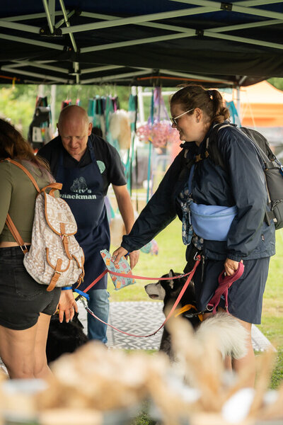 Bezoekers praten met standhouders onder de tent tijdens het Just Woofing evenement