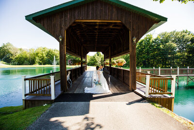 Couple kissing on the covered bridge at Majestic Woods