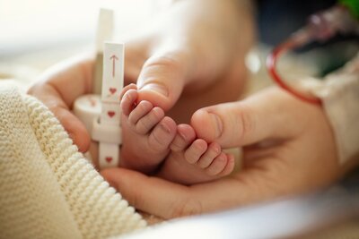 A new mom gently holds her baby's feet during a fresh 48 session at Winnie Palmer Hospital. 