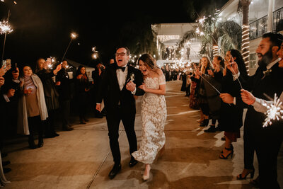 Bride and groom on wedding day leaving through a sparkler exit tunnel in Houston, Texas