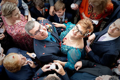 married couple looking upwards as confetti is thrown over them