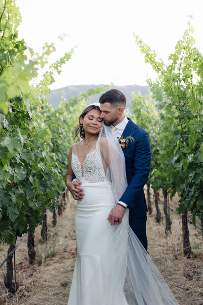 Groom carries bride down isle at Contento Vineyards in Hopland, California