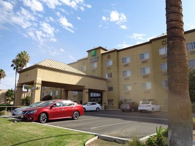 Exterior of Holiday Inn Express in Bakersfield, California on a sunny day with a palm tree in front