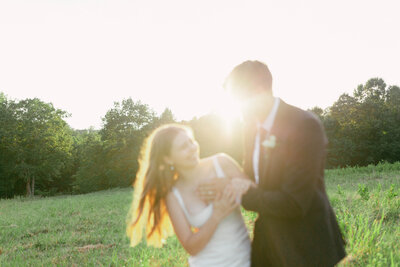 Bride and Groom Embracing and Laughing During an Outdoor Elopement, Bathed in Sunlight