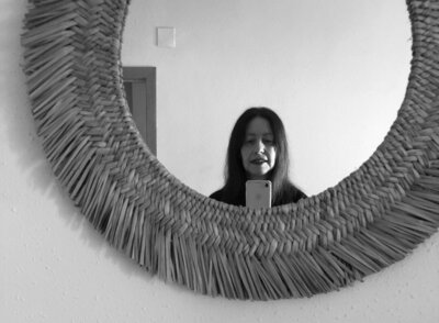 Betina Cunado, The Copywriter Translator looking at herself in the mirror.