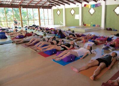 Students enjoy deep relaxation in Savasana at the end of a yoga class in our 200 Hour YTT Program in Costa Rica