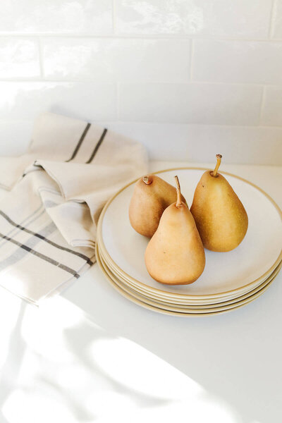 Golden Pears on a Gold and White Plate with Cream Napkins - Brenda Chadambura