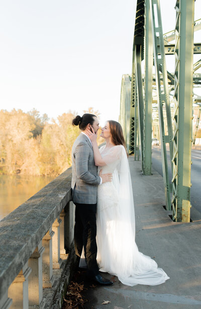 couple kissing on a bridge