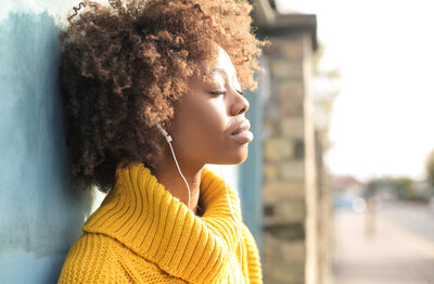 Black woman listening to calming music to help with her anxiety.