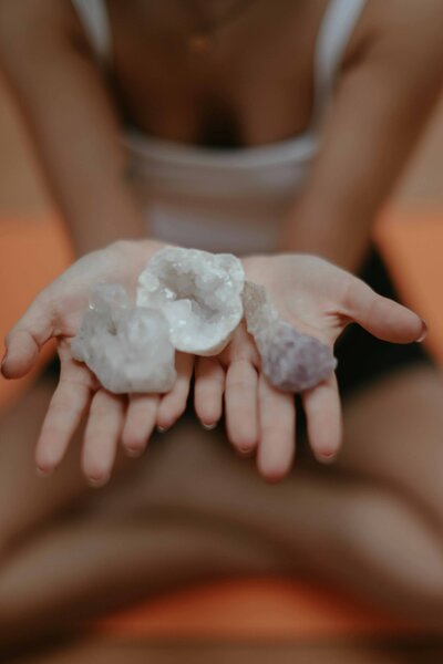 A person holding healing crystals in their hands during a meditation session, symbolizing energy work, spiritual balance, and holistic healing.