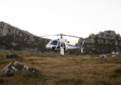 Photo of elopement couple kiss in the Dolomites while getting back into the helicopter, Photo taken by kollar photography. Arizona Elopement Photographer