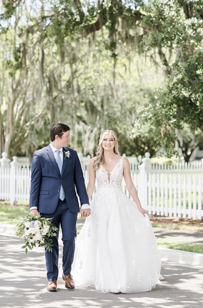 bride and groom walking near a bed and breakfast