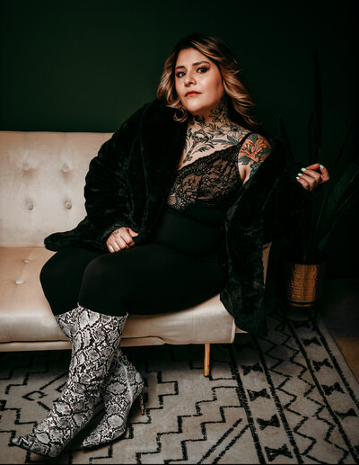 woman in studio sitting on white bench wearing black pants and black top