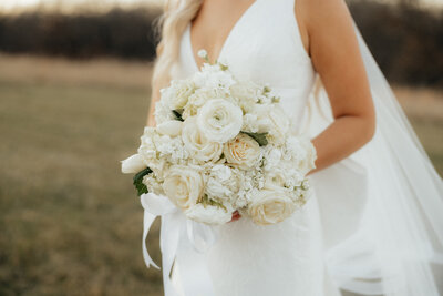 A beautiful white wedding bouquet held by the bride.