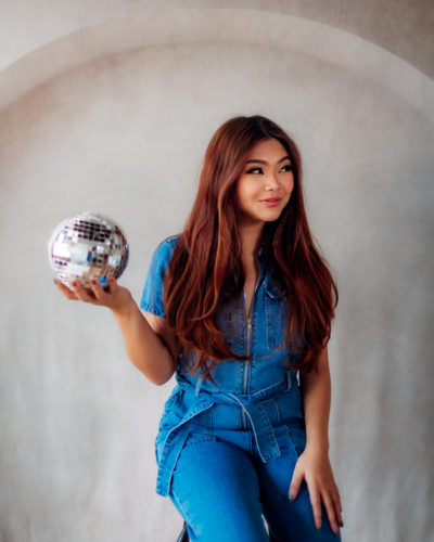 Kemotion owner holding a disco ball, highlighting her creative approach to website design for service-based businesses.