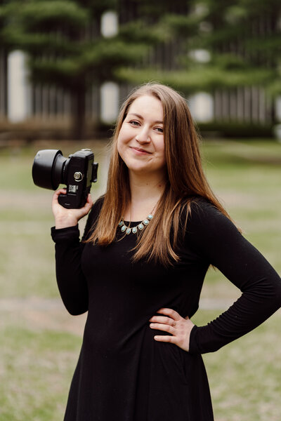Rebecca Loomis Photography holding a Canon Camera