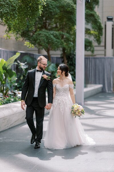 Stylish couple smiles at each other during their downtown engagement session