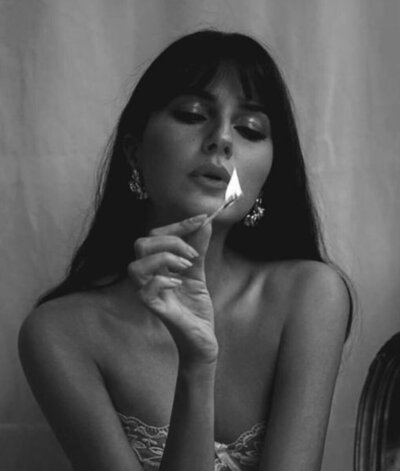 A woman holding a lit match, symbolizing the spark of intuition and self-discovery.