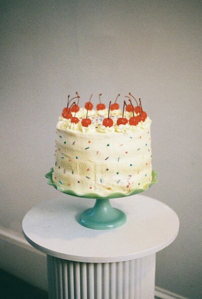 Colorful vintage inspired wedding cake with cherries on top. Photography by Rhode Tripper Photography