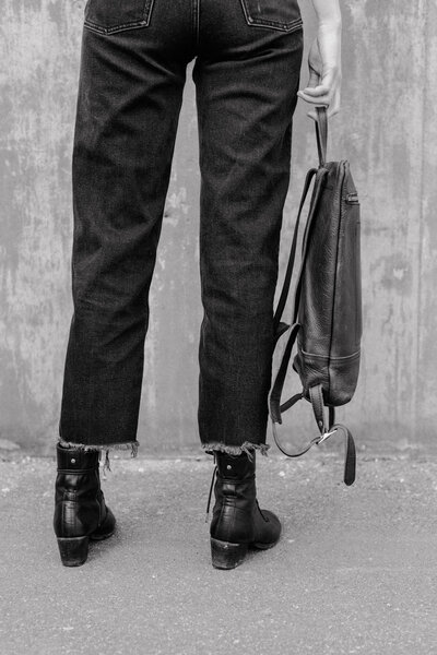 woman in jeans carrying a bag