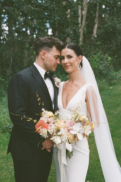 Bride and groom share a joyful moment during their outdoor Bearspaw Golf Course Calgary wedding, styled with romantic florals and modern details by Melissa Alison Events.