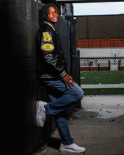 a calhoun high school senior poses for his senior portraits on the football field