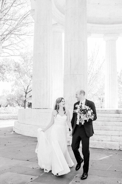 bride and groom smiling at each other as they walk towards the camera