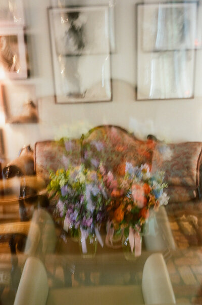 Simple floral arrangement and candles with shadows cast over the table for Austin wedding