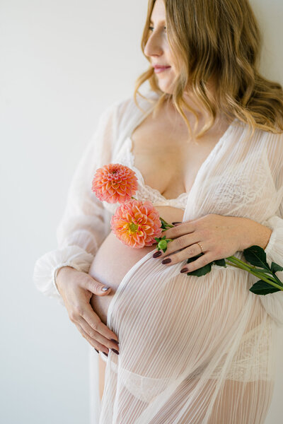 close up of a pregnant mama holding flowers
