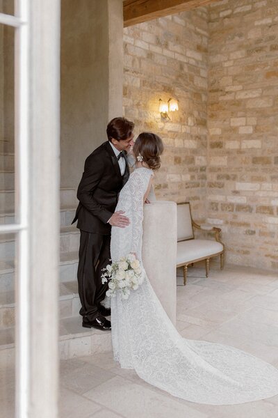 Bride looks over her new husband shoulder and smiles