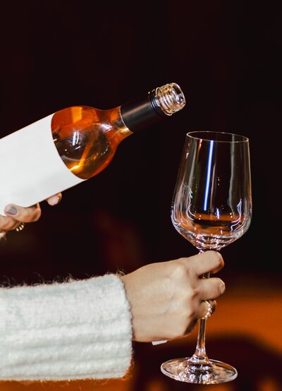 a woman pouring a glass of wine