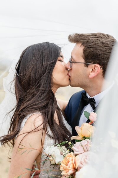 The Paseo Weddings Bride and Groom kissing in desert