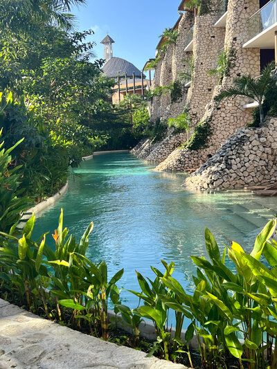 The resort's tranquil pool, framed by lush plants, offers an idyllic setting for destination weddings.