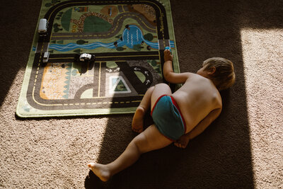 In home family session Boy playing with cars