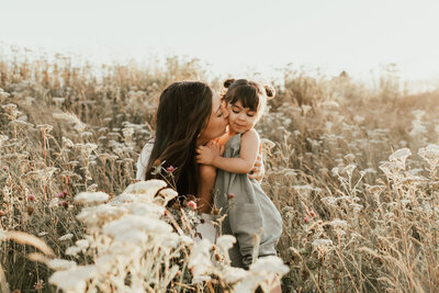 mom kissing daughter