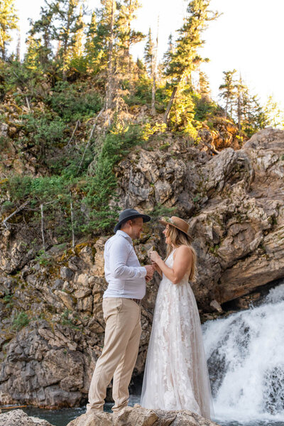Indianapolis Wedding Photographer and Videographer captures bride and groom exchange their vows on a rock in front of a waterfall