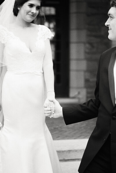 black and white photo of couple holding hands on wedding day