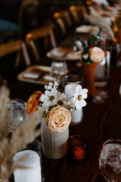 A wedding reception table with flower bouquets on it