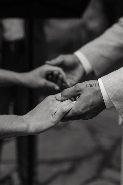 Newlyweds hold hands during their vow exchange