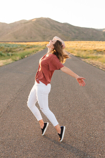 Girl in white jeans doing the michael Jackson pose with Idaho mountains in the background