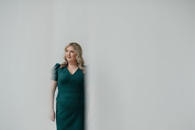 Melissa Lawrence looks into the distance while wearing a green dress