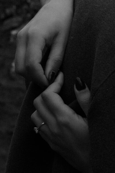 Black-and-white detail of a bride’s hands, captured in a moody fine art style by Scotland wedding and elopement photographer Aly Robinson.